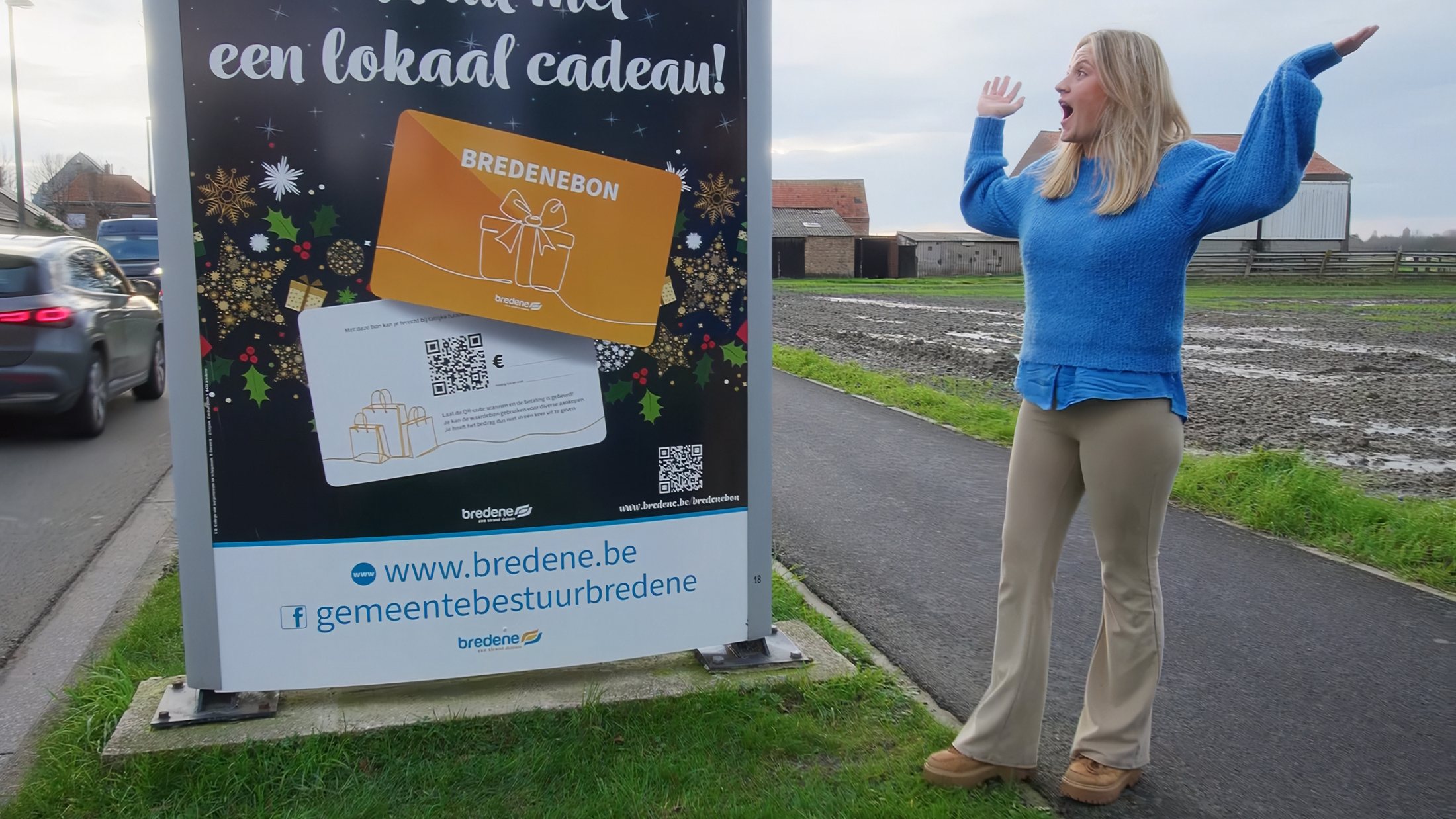 Enthousiaste vrouw met de armen in de lucht naast een affiche van de Bredenebon