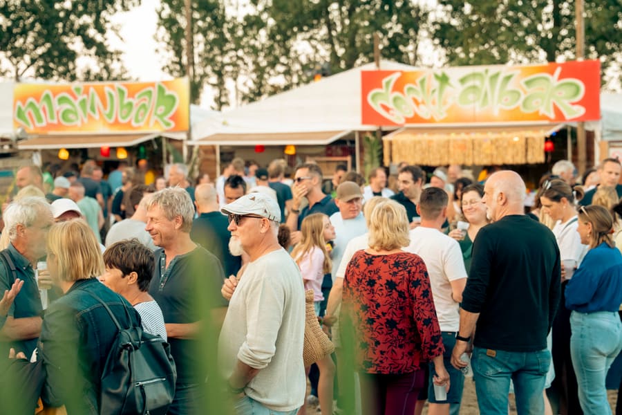 Bezoeker met pet en baard die een drankje drinkt