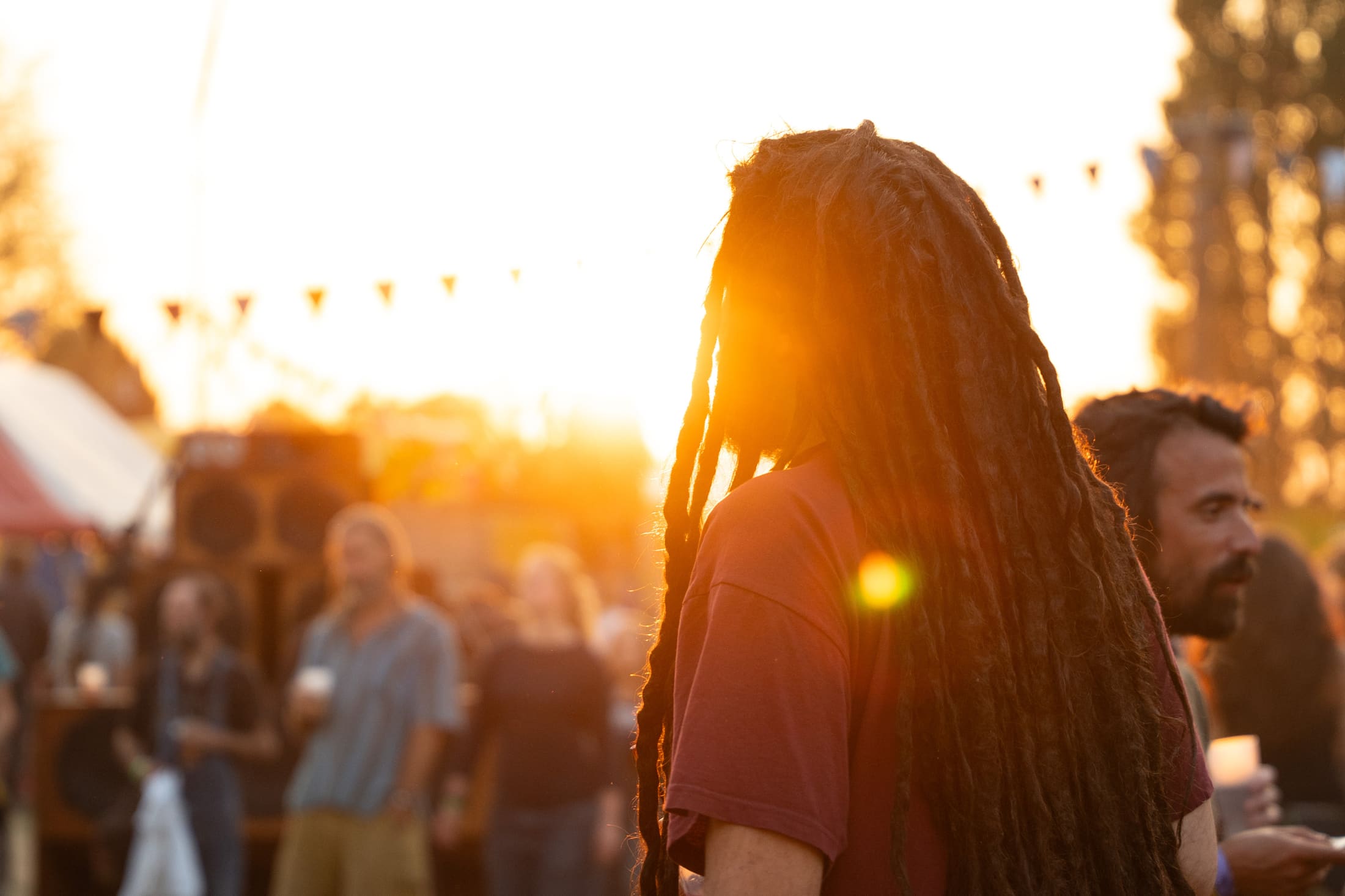 Recap Irie Vibes Festival: festivalbezoeker met dreadlocks in tegenlicht