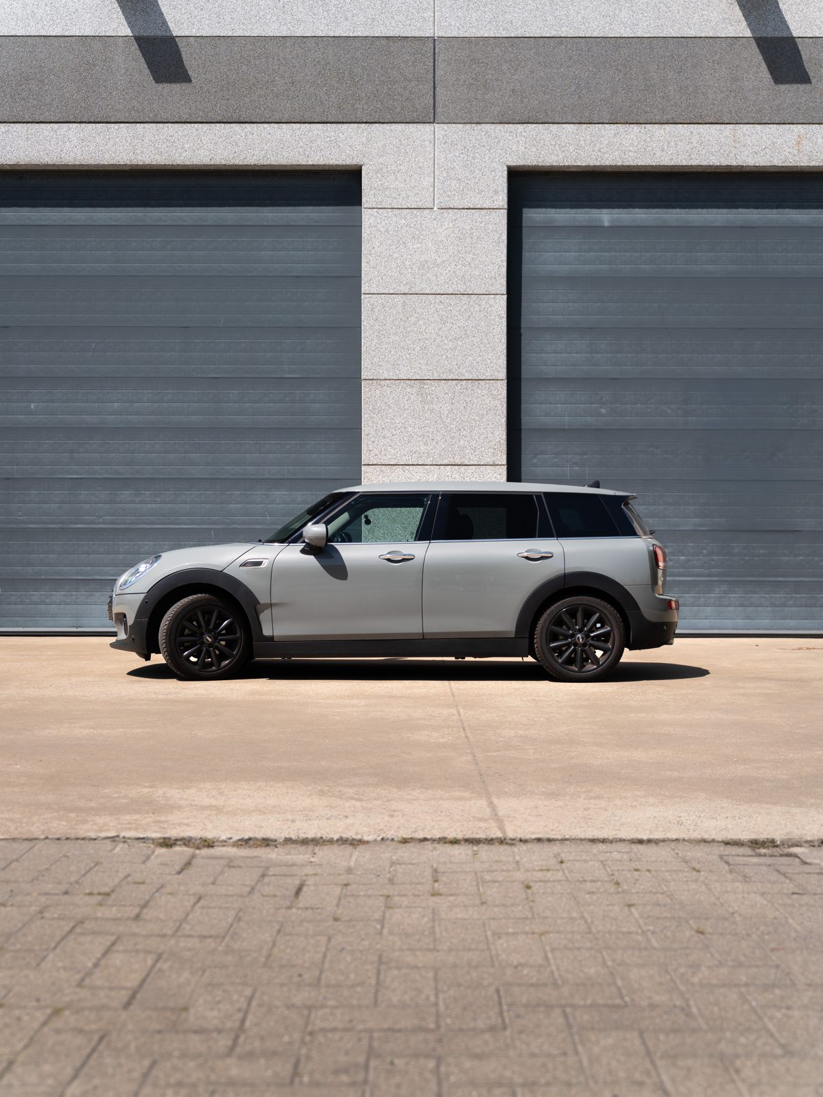 Mini Clubman van opzij voor twee grijze garagepoorten