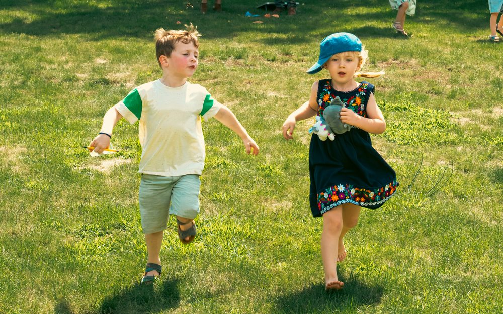 Twee kinderen die over het gras rennen