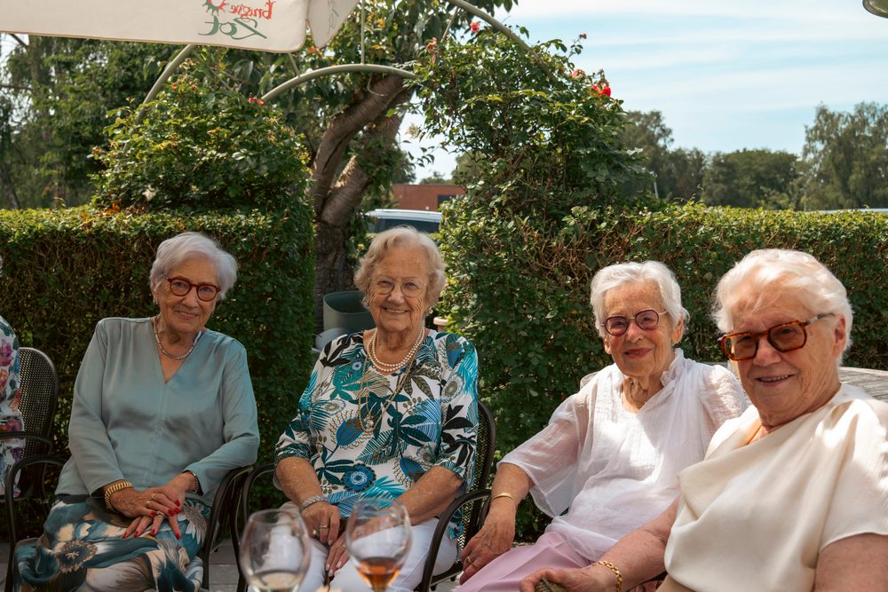 Vier dames samen op een bank in de tuin