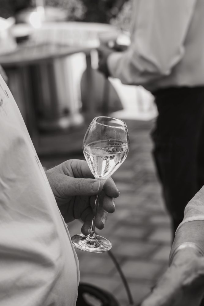 Hand die een glas wijn vasthoudt, in zwart-wit