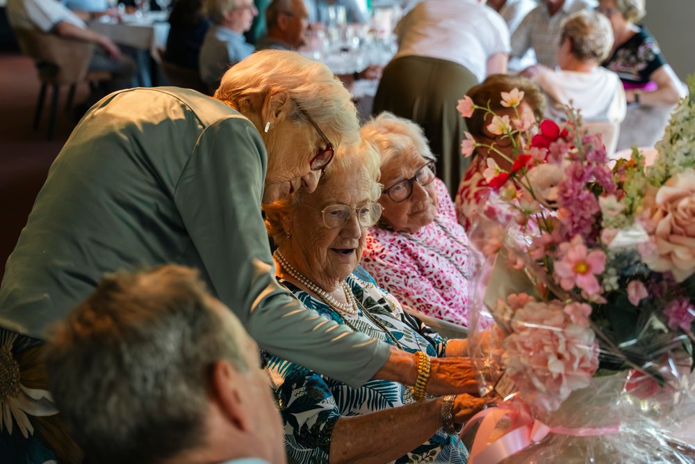Gasten aan tafel tussen de bloemen
